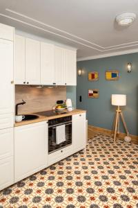 a kitchen with white cabinets and a stove top oven at Warnemünde: Apartment KAJÜTE - nur 3 Gehminuten zum Strand in Warnemünde