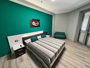 a bedroom with a bed and a green wall at Siclari B&B-Rooms&Suite in Taurianova