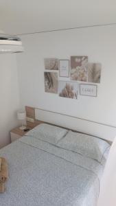 a bedroom with a bed with pictures on the wall at MET&GOLF OLIVA NOVA BEACH JARDIN in Oliva