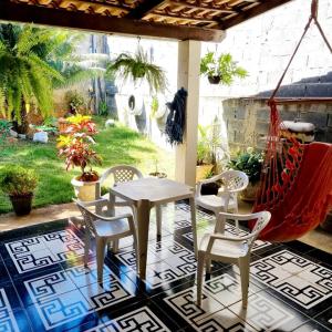 a patio with a table and chairs and a hammock at Casa exclusiva Cordisburgo in Cordisburgo