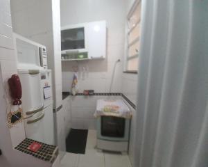a small kitchen with a refrigerator and a stove at 2 quartos, completo com privacidade total, smarttv, Lapa, aeroporto, rodoviária , maracanã, metrô, etc in Rio de Janeiro