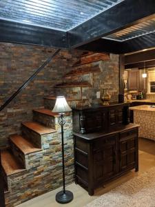 a living room with a brick wall and a lamp at Breckenridge Chalet near Yosemite. Dog friendly! in Groveland