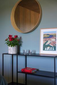 un estante con un jarrón de flores y un espejo en La maison en Provence, en Graveson