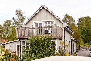 a house with a balcony on top of it at Nyhagens trädgård och B&B 