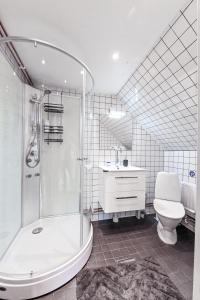 een badkamer met een douche, een toilet en een wastafel bij Nyhagens trädgård och B&B 