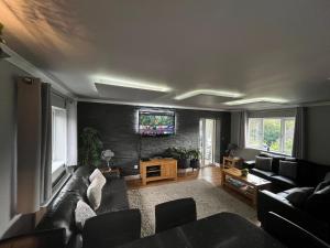 a living room with a couch and a flat screen tv at Brae Hoose in Arisaig