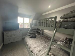 a bedroom with two bunk beds and a television at Brae Hoose in Arisaig