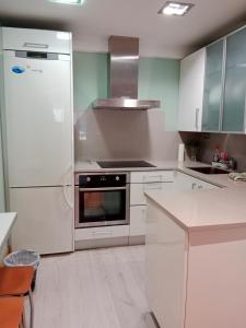a kitchen with white cabinets and a refrigerator at Pensión San Vicente in San Sebastián