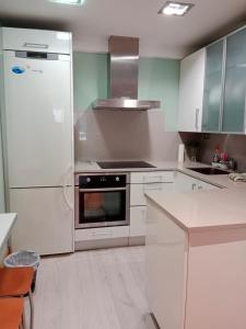 cocina con armarios blancos y nevera en Pensión San Vicente, en San Sebastián