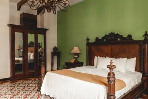 een slaapkamer met een groot bed en een groene muur bij Hotel & Restaurante La Gran Francia in Granada