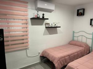 Habitación con 2 camas individuales y sábanas rosas. en ALOJAMIENTO CERRO DEL CABEZO, en Andújar