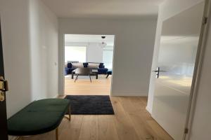 een woonkamer met een groene stoel en een kamer met een tafel bij Bel Appart 6/8 p - à 5 min Disney Land in Chessy