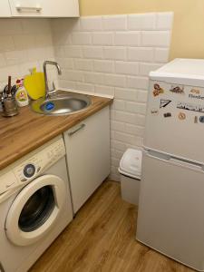 een keuken met een wastafel en een wasmachine bij iAparts Богенбай батыра-Шагабутдинова in Alma-Ata