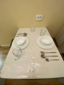 een witte tafel met borden en bestek erop bij iAparts Богенбай батыра-Шагабутдинова in Alma-Ata