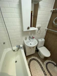 een badkamer met een wastafel, een bad en een toilet bij iAparts Богенбай батыра-Шагабутдинова in Alma-Ata