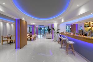 a lobby with a bar with chairs and tables at Oceanis Park Hotel in Ixia