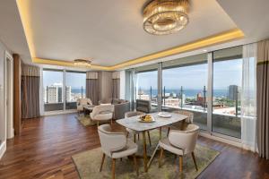 伊斯坦堡的住宿－泰坦尼克港口巴克科伊酒店，客厅配有桌椅和大窗户