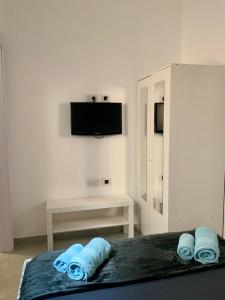a bedroom with a bed with blue towels and a tv at New 2 rooms flat fully equipped 5 min to Bat Yam beach near Tel Aviv in Bat Yam