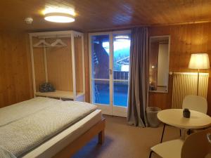 een slaapkamer met een bed en een groot raam bij Casa Crap in Trin