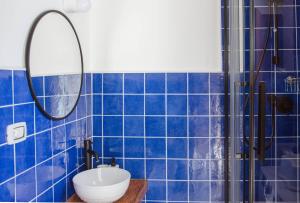 Baño de azulejos azules con lavabo y espejo en Casa aMmare, en Pioppi