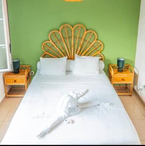 una camera da letto con un grande letto bianco con testiera in legno di VILLA SANTIBANEZ - Villa avec piscine à St André a Le Patelin