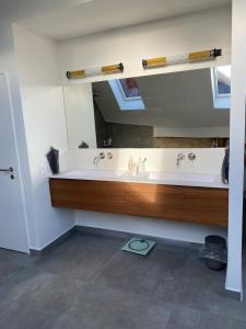 a bathroom with two sinks and a large mirror at Grande villa avec piscine sur la côte in Bursins