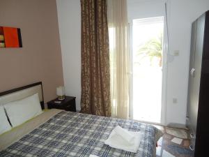 a bedroom with a bed and a large window at Studios Lainis in Toroni