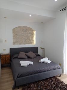 una camera da letto con un letto e due asciugamani di Casa Vacanze Borgo Gulini da Anna a Petralia Soprana