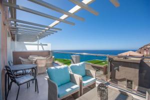 Luxury penthouse, panoramic sea view في موجان: شرفة مع كراسي وطاولة وإطلالة على المحيط