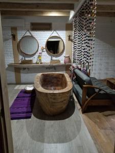 una grande vasca in legno in un bagno con due specchi di Hotel Bendita Luna a Mazunte