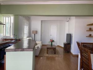 a kitchen and living room with a couch and a table at ATICO ALFAQUEQUE in Seville