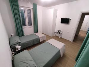 mały pokój z 2 łóżkami i telewizorem w obiekcie Grigio Perla Panigale, villetta con giardino e parcheggio privato gratuito w Bolonii