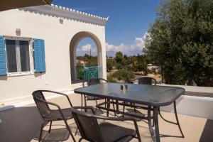a table and chairs on a patio with a view at Mat Met House in Spetses