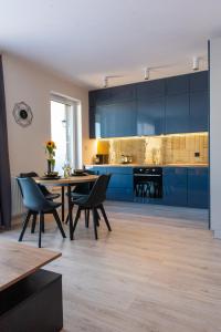 una cucina con armadi blu, tavolo e sedie di Marcelina Apartment a Rumia
