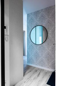 a hallway with a round mirror on the wall at Marcelina Golden Apartments przy Aquapark Reda in Rumia