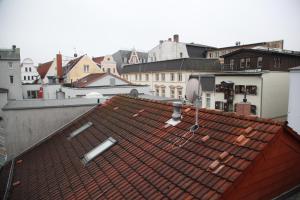 Blick auf das Dach einer Stadt mit Gebäuden in der Unterkunft Wunderschöne Dachgeschoss - Maisonette (108qm - 3.OG) in Rostock