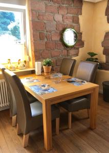 a dining room table with chairs and a brick wall at Gemütliches Apartment Garden View in Ramstein-Miesenbach