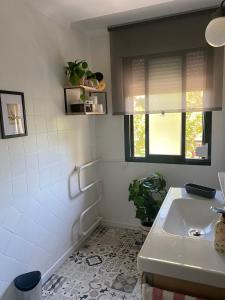 baño blanco con lavabo y ventana en Acogedor apartamento en pleno corazón de Triana, en Sevilla