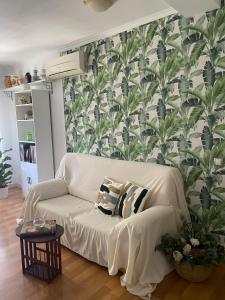 białą kanapę w salonie z tapetą w obiekcie Acogedor apartamento en pleno corazón de Triana w Sewilli