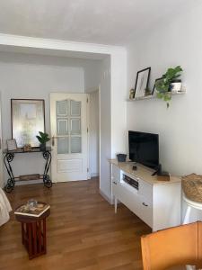 salon z telewizorem na komodzie w obiekcie Acogedor apartamento en pleno corazón de Triana w Sewilli