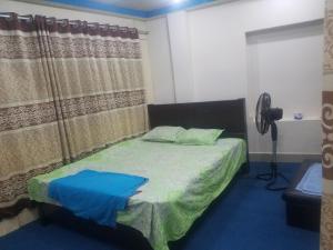 1 dormitorio con 1 cama con alfombra azul en Kompass Homestay - Affordable AC Room With Shared Bathroom in Naya Paltan Free WIFI, en Dhaka