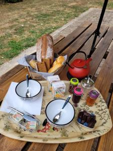 uma mesa com dois pratos de comida e um cesto de pão em Prince des carrés em Saint-Malo-en-Douziois