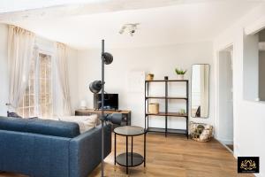 a living room with a blue couch and a table at Alvéo in Fontainebleau