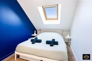 a bedroom with a bed with two blue pillows at Alvéo in Fontainebleau