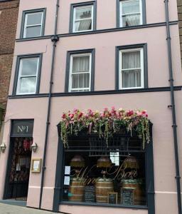 a pink building with flowers in a store window at Mademoiselle's Boutique Holiday Accommodation in Whitby