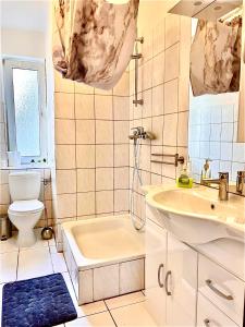 ein Badezimmer mit einem Waschbecken, einer Badewanne und einem WC in der Unterkunft Geräumige Wohnung im Herzen Kassels in Kassel