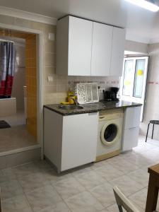 a kitchen with a sink and a washing machine at Ocean Corner Belém in Lisbon