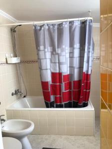 a bathroom with a red and white shower curtain at Ocean Corner Belém in Lisbon