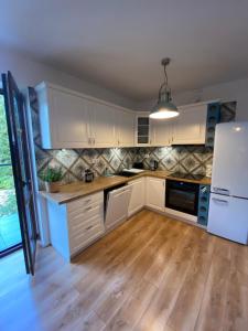 kuchnia z białymi szafkami i białą lodówką w obiekcie Apartament Chleb i Wino w mieście Krynica Zdrój