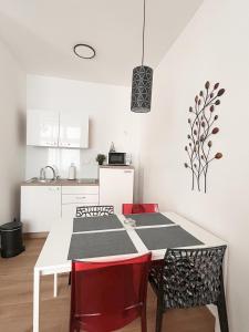 een keuken met een witte tafel en rode stoelen bij Verde in Zagreb